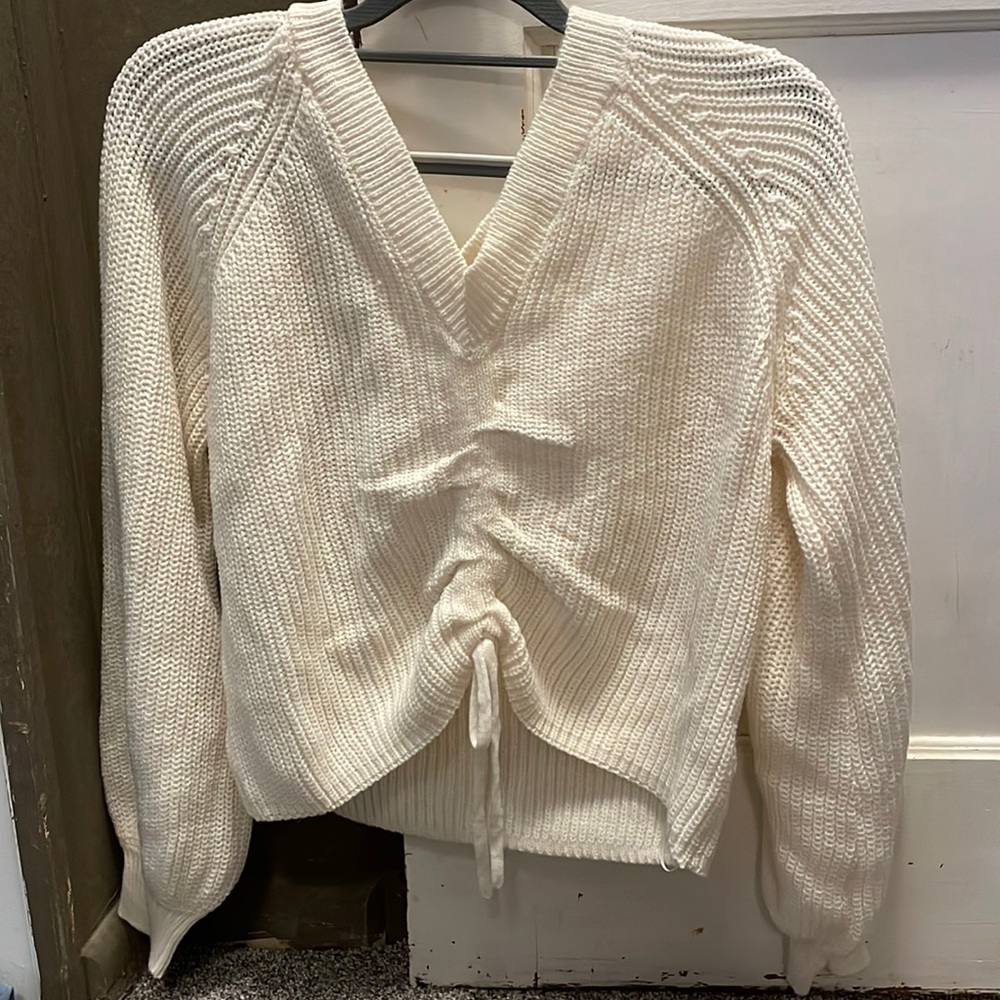 sweater, cropped but can be adjusted in-front